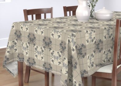 Tablecloth with art nouveau swans bordered by flowers in half drop on a checked pattern. Main color is "silver Cloud" (sand)