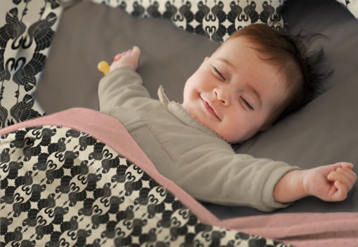 Baby sleeping in Swan Dance duvet cover.