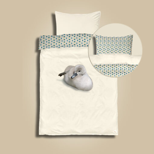 Diy junior bedding kit "Geo The Duckling". Front with cute little duckling on off white (pristine) background. Back side in olive & blue colored geometric shaped pattern. Pillowcase and duvet cover to sew in a cotton satin fabric